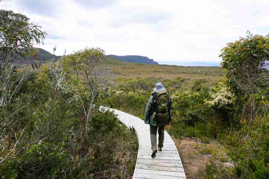 a womancarrying a backpack on the the 3 Capes walk in Tasmania