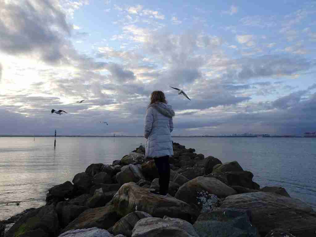 woman looking at the stormy sky at Bonna Point in Kurnell, Sydney