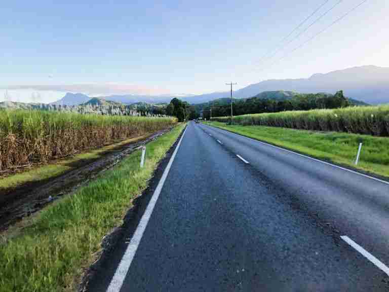 a road stretching into the distance with mountains in the background after visiting the Daintree Rainforest