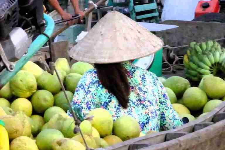 Vietnamese woman in a boat surrounded by melons