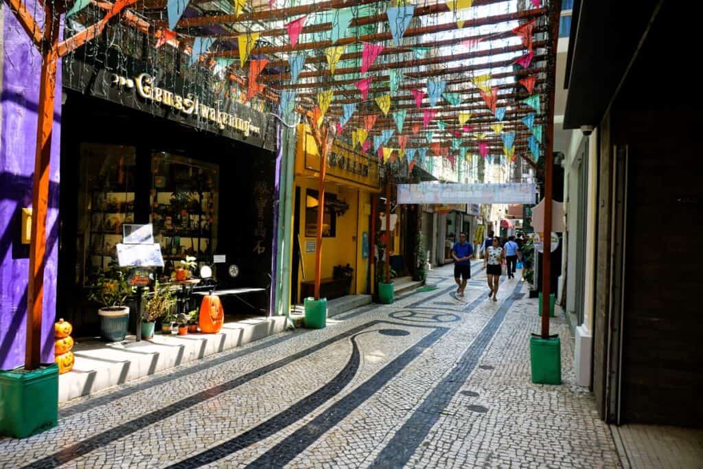 Narrow laneway with a decorative tiled path and colourful flags overhead