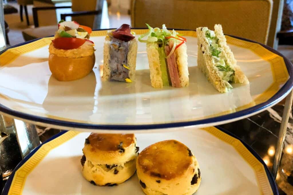 Gourmet sandwiches and scones served on a silver tray
