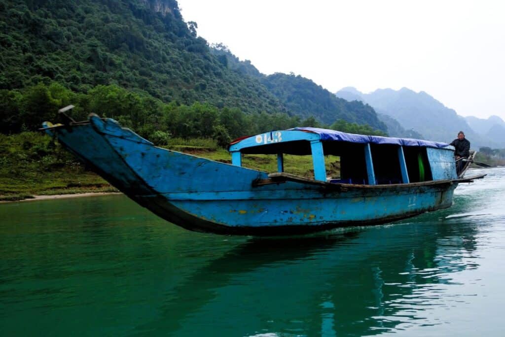 a blue boat on the Son River in Phong Nha Vietnam