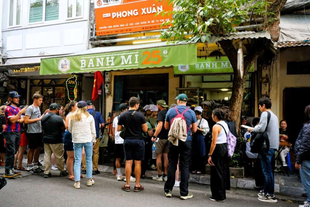Tourists queuing for a traditional Banh Mi baguette in Hanoi Vietnam
