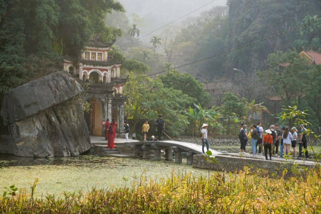 Ninh Binh Travel guide Bridge over a lake to the Bich Dong Pagoda at the foot of a mountain
