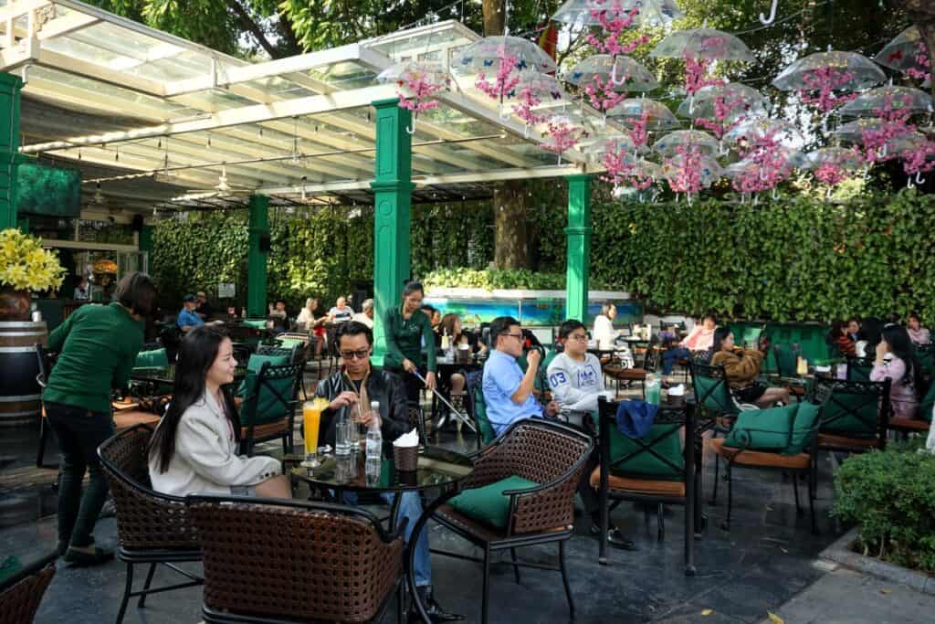 people relaxing at an outdoor Bon Mua Cafe in Hanoi Vietnam