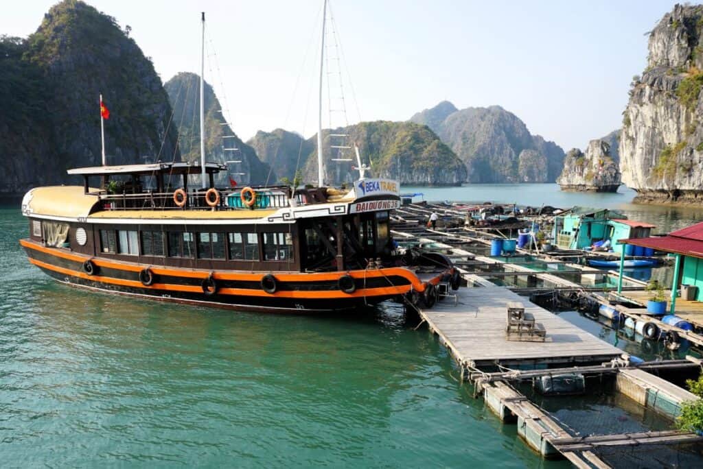 colourful cruise boat moored at a wooden jetty with mountains behind