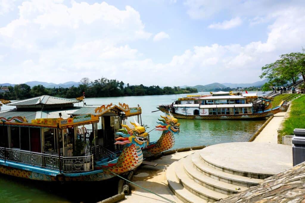 dragon boats with colourful dragon heads moored on a  river