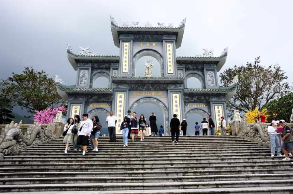 stairs leading to a grey temple gate with archways