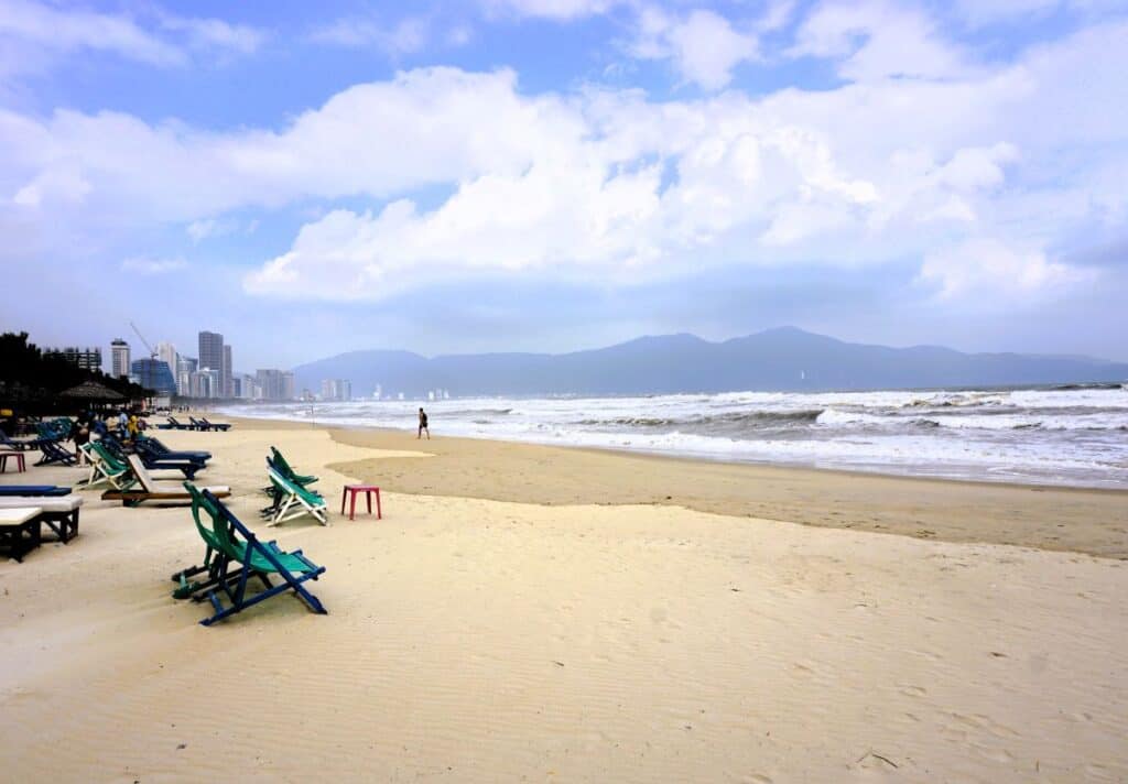 sandy beach with surf and deckchairs 