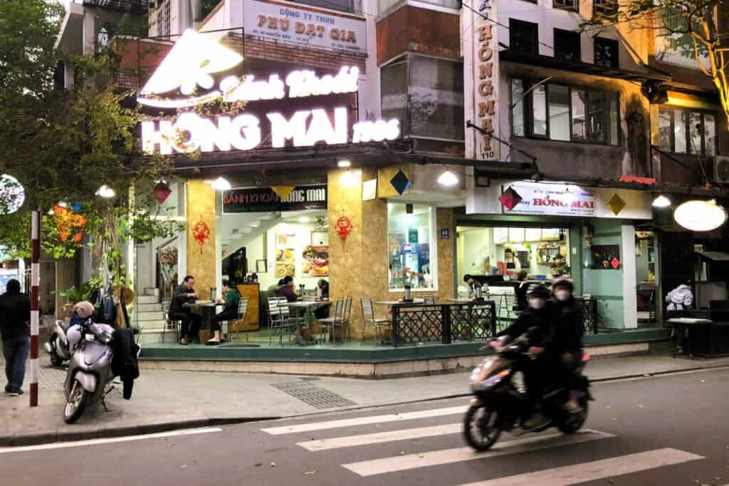 Restaurant with outdoor tables and neon lights