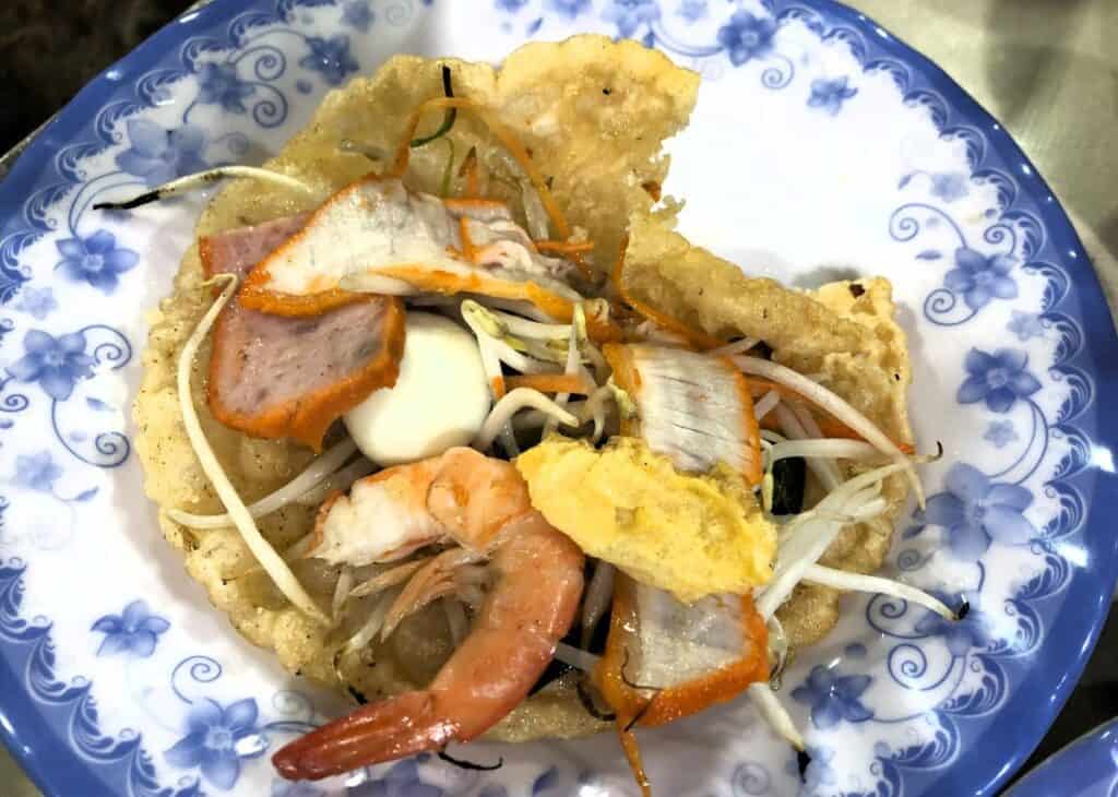 pancake with prawns and been sprouts on a blue floral plate