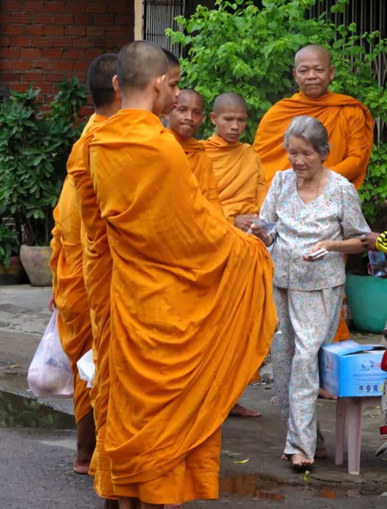 Monks dress in saffron robes collecting alms