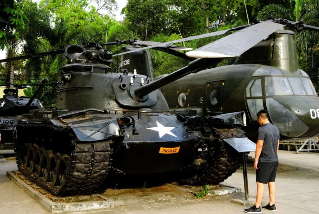 a man looking at an army tank and aeroplane