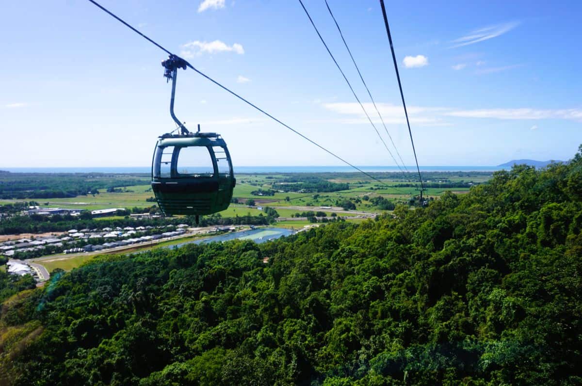 cable car over lush forests with sweeping coastal views